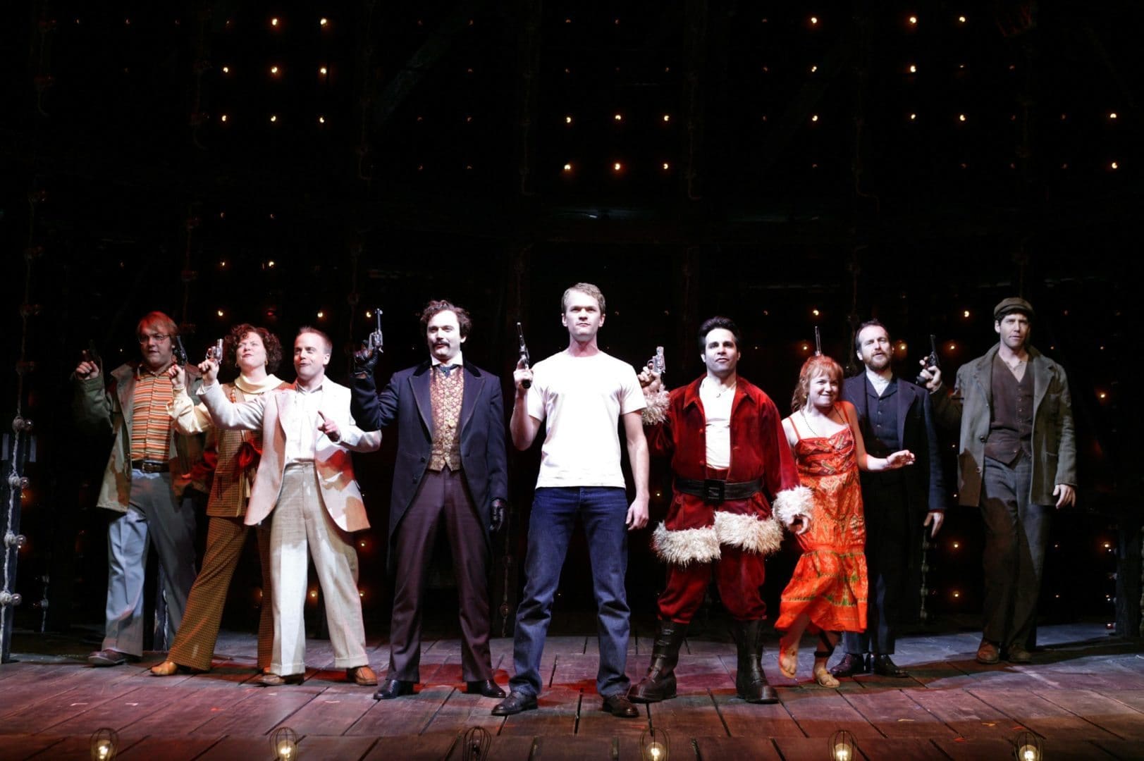 Roundabout Theatre Company's Assassins
(l-r) Alexander Gemignani, Becky Ann Baker, Jeffrey Kuhn, Michael Cerveris, Neil Patrick Harris, Mario Cantone, Mary Catherine Garrison, Denis O'Hare, James Barbour.  Photo credit: ©2004, Joan Marcus